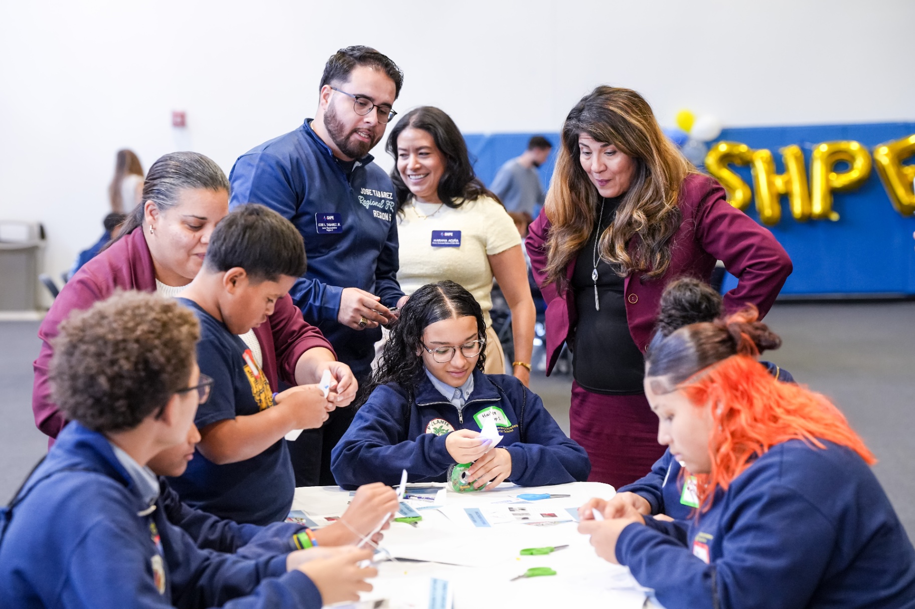 Students and SHPE volunteers collaborating at Día de Ciencias